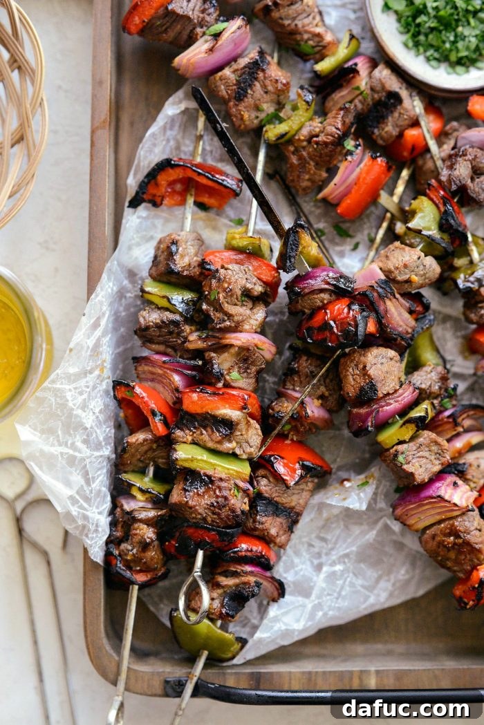 Delicious grilled marinated steak kebabs on a wooden serving tray, ready to eat