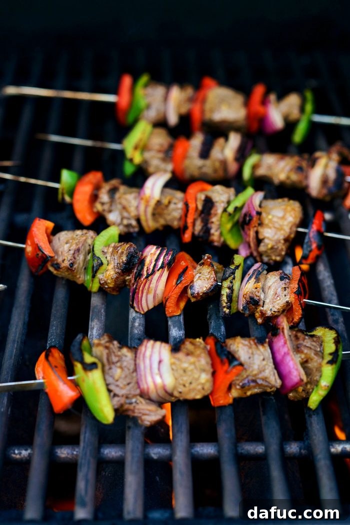 Close-up of grilled steak kebabs on the grill showing distinct char marks