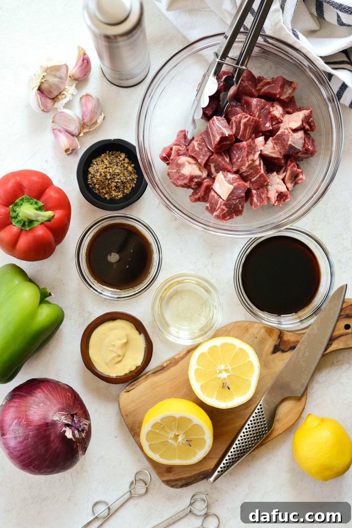 Assortment of fresh ingredients for grilled marinated steak kebabs laid out on a surface