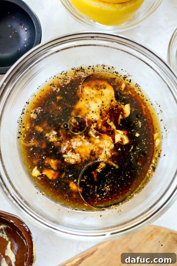 Freshly mixed marinade ingredients in a clear glass bowl