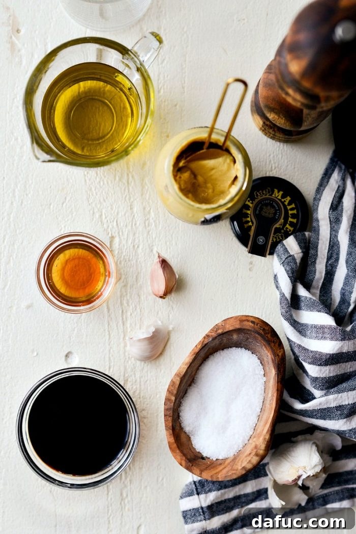 Signature Balsamic Vinaigrette 3 A selection of house balsamic vinaigrette ingredients carefully laid out on a clean surface, featuring olive oil, balsamic vinegar, fresh garlic cloves, Dijon mustard, and golden honey.