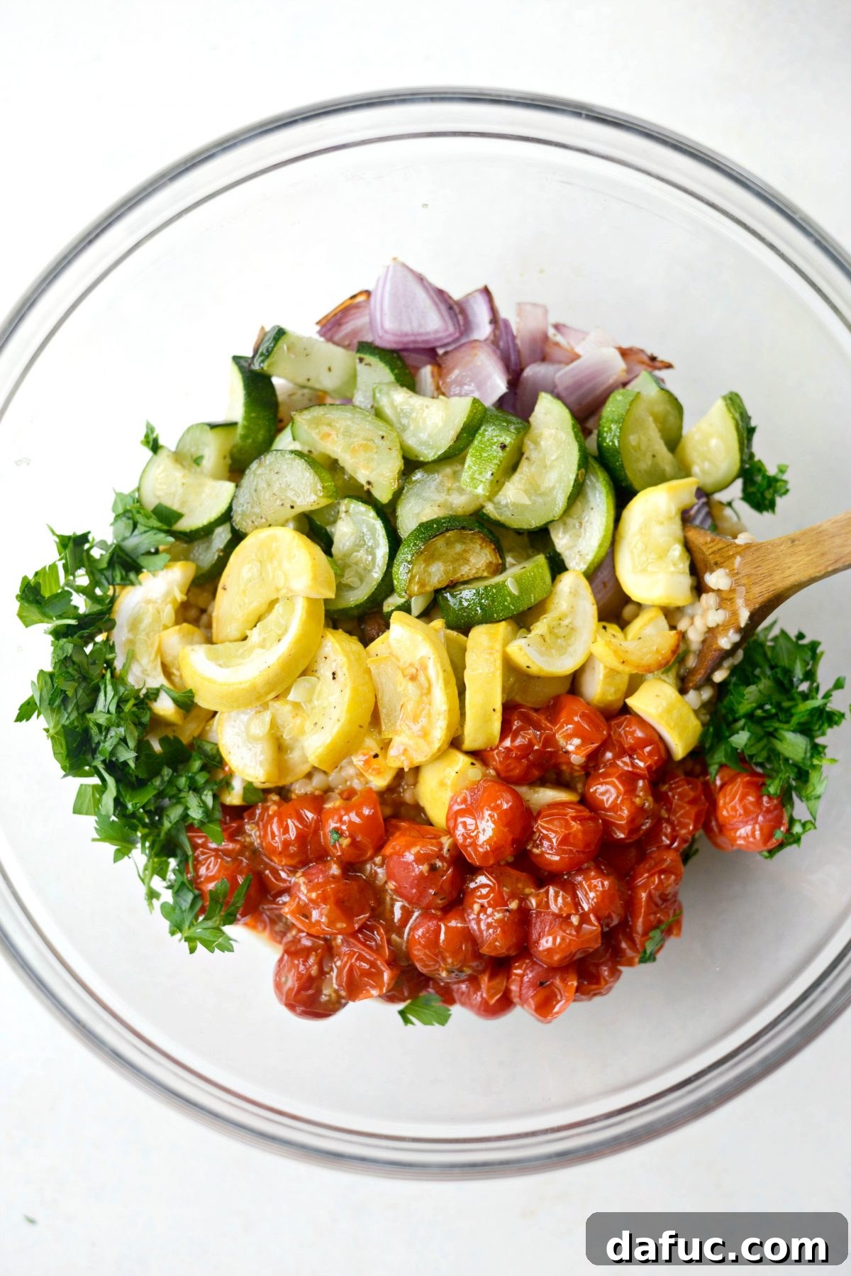 Aromatic North African Shrimp with Vibrant Summer Couscous 15 Combining couscous and roasted vegetables in a mixing bowl.