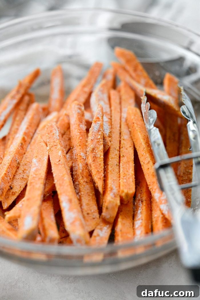 Sweet potato fries fully coated with seasoned cornstarch, ready for baking