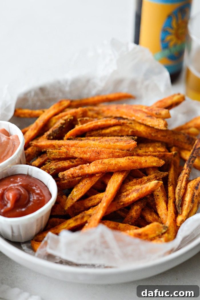 Close-up of baked sweet potato fries on a baking sheet, showcasing their crispy texture