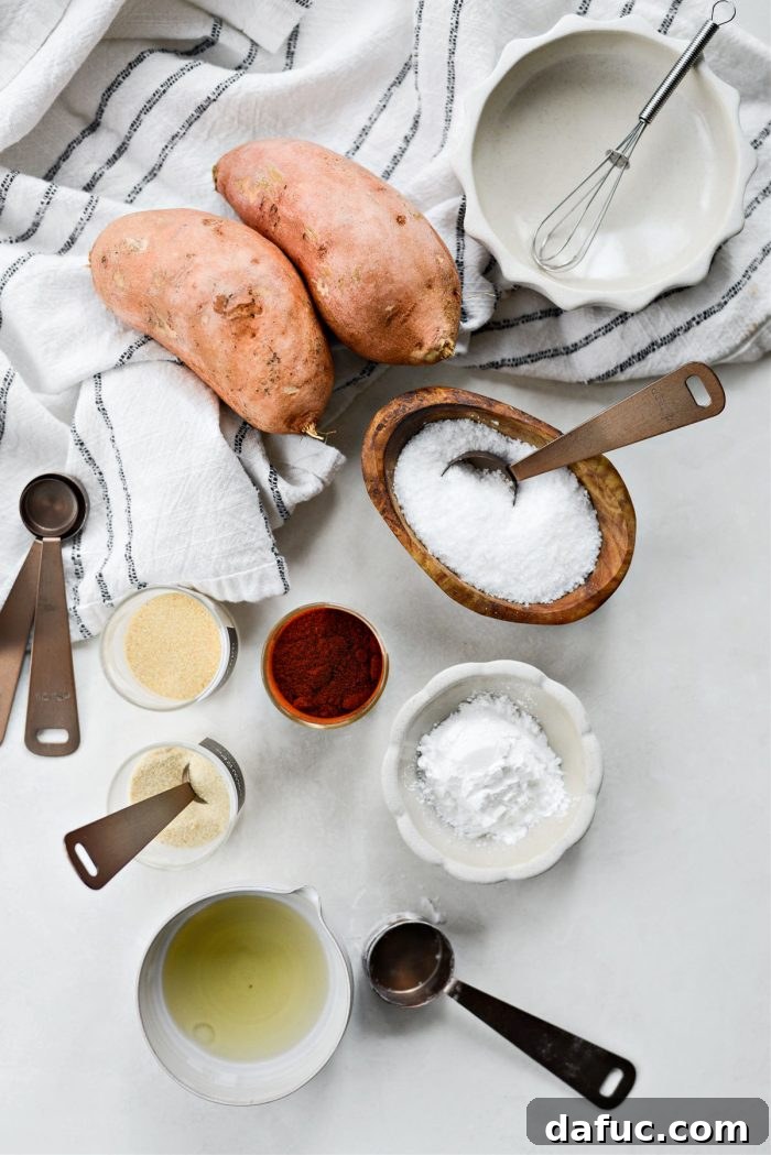 Ingredients for making crispy baked sweet potato fries laid out on a table