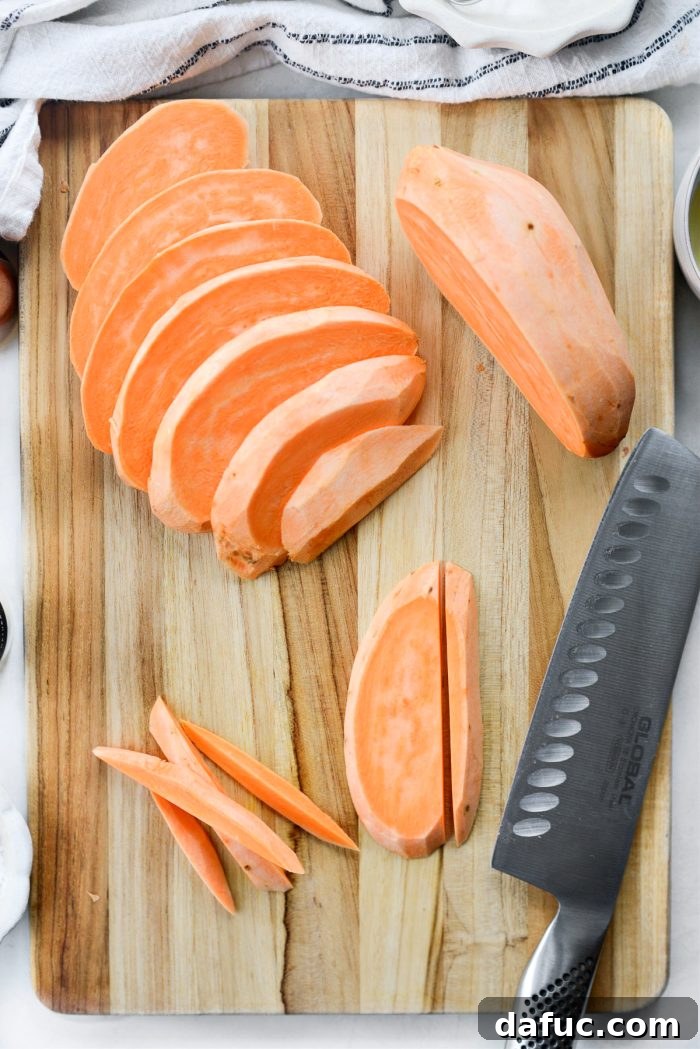 Sweet potatoes being sliced into uniform 1/4-inch planks and then into fries