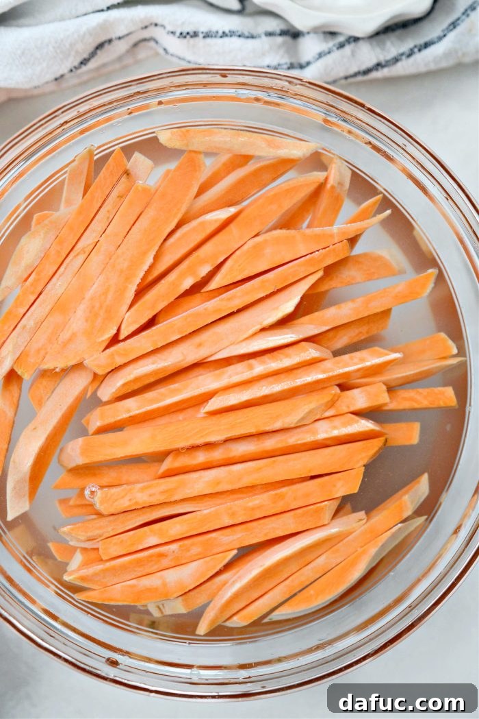 Sweet potato fries soaking in a bowl of cold water