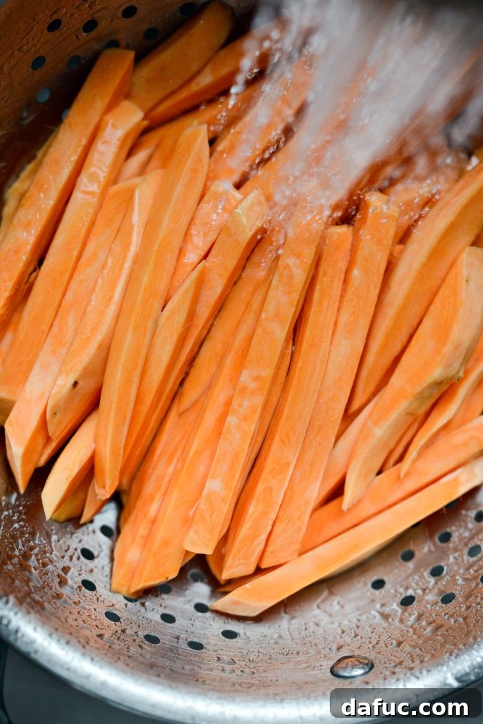 Rinsed and drained sweet potato fries after soaking, ready to be dried