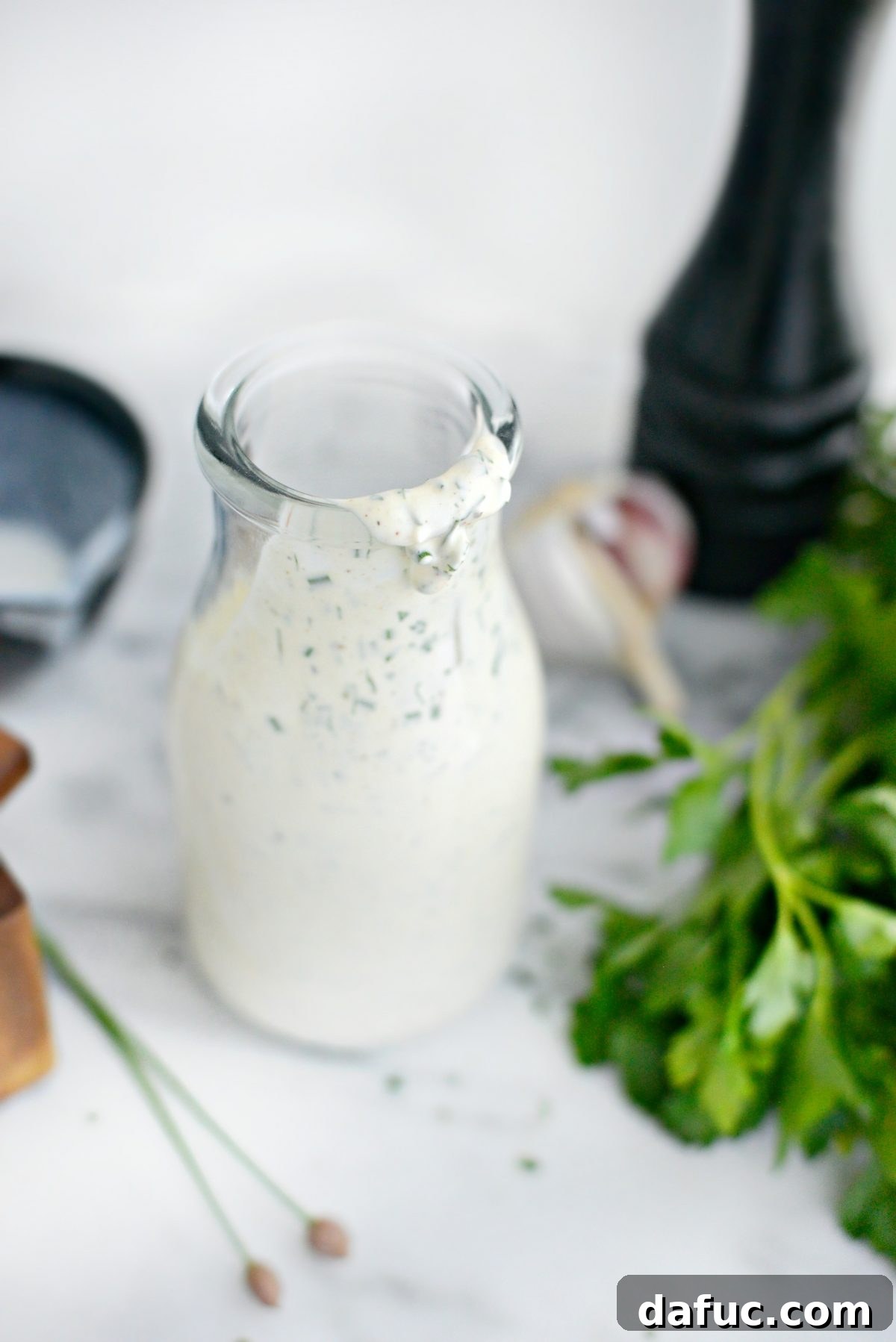 Farmhouse Ranch 11 Buttermilk Ranch Dressing poured into a rustic bowl with a spoon