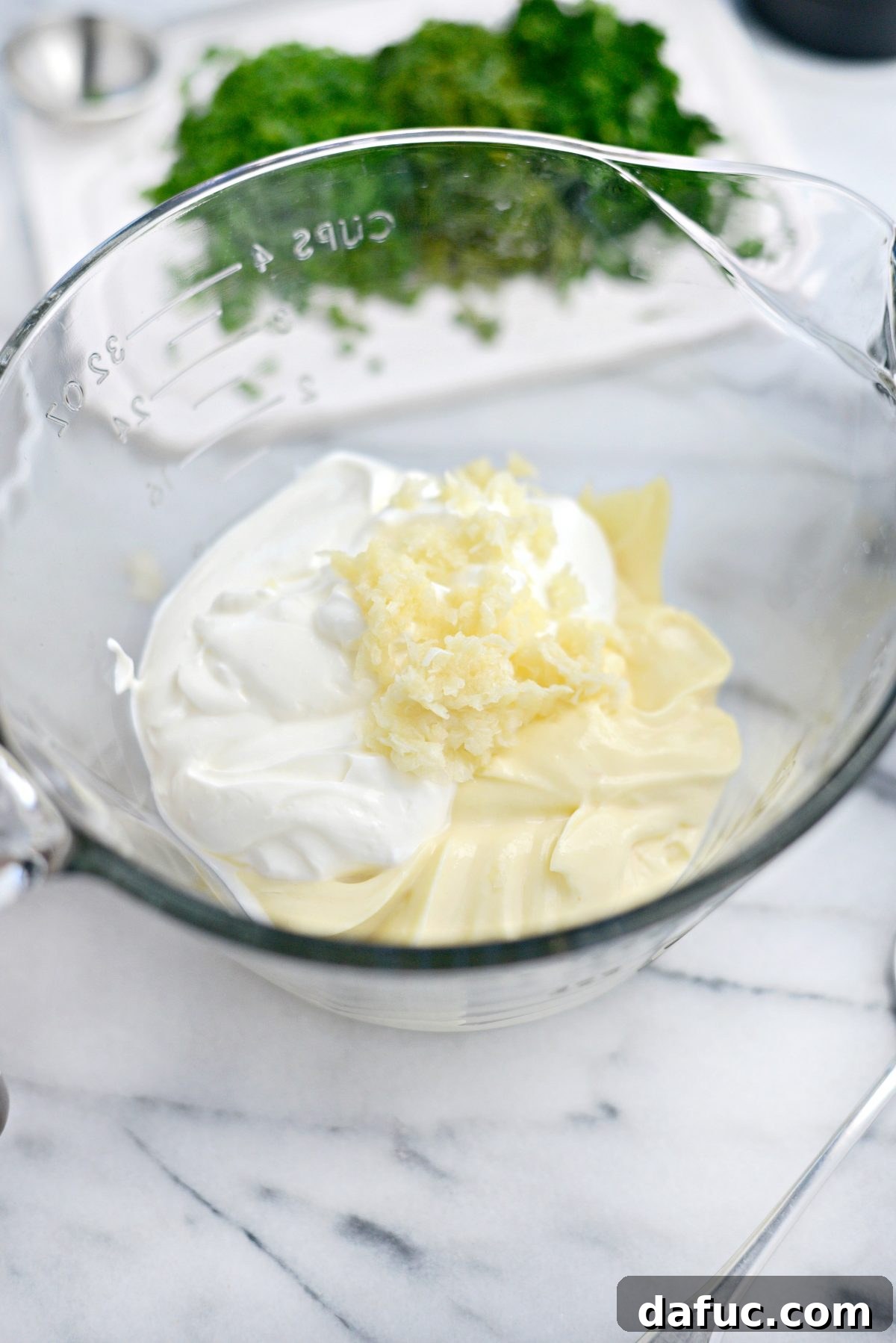Farmhouse Ranch 4 Adding mayonnaise, sour cream, and grated garlic into a large measuring cup