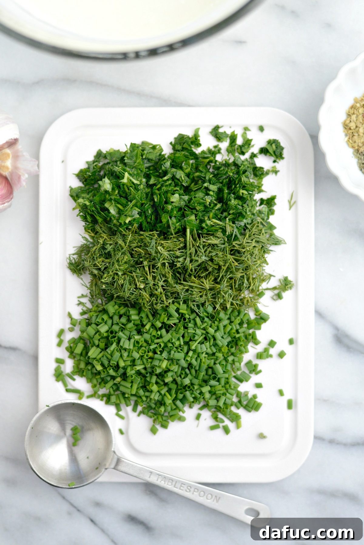 Farmhouse Ranch 7 Minced fresh herbs including chives, dill, and parsley in small piles