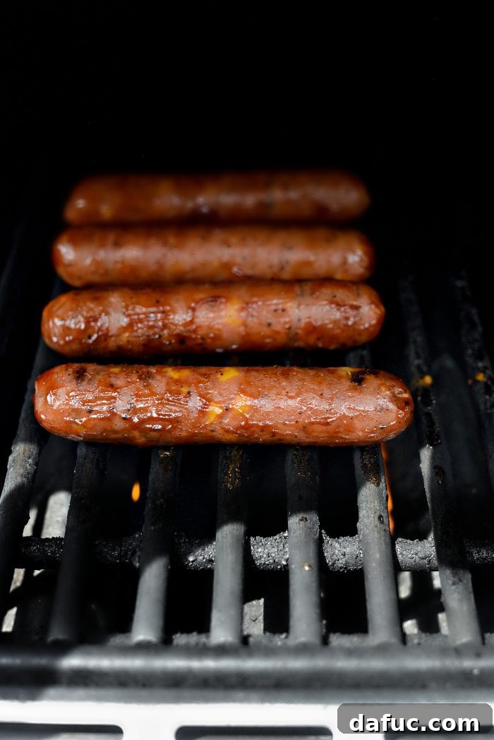 Smoky BBQ Glazed Chicken Brats 6 Close-up of grilled chicken brats, sticky and caramelized with BBQ sauce, showing perfect grill marks.
