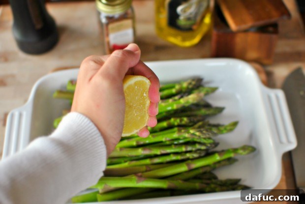 Squeezing fresh lemon over asparagus