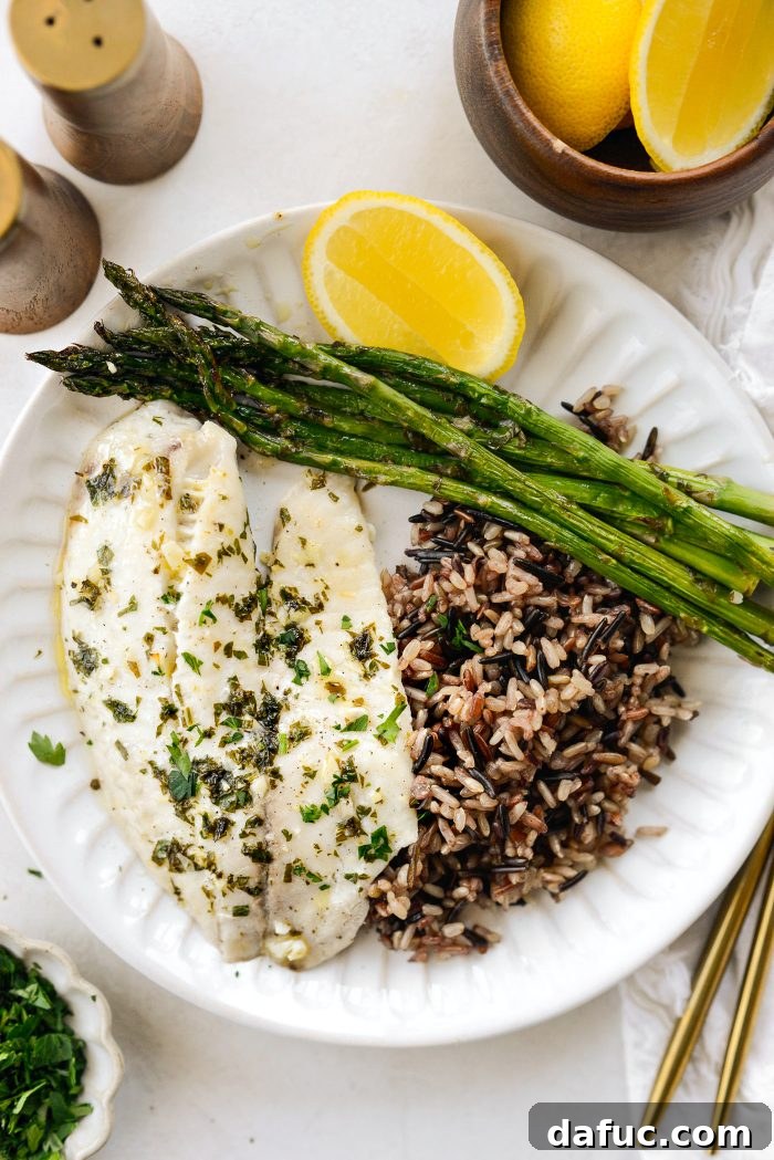 Delicious Sheet Pan Lemon Garlic Tilapia with Asparagus served on a baking sheet