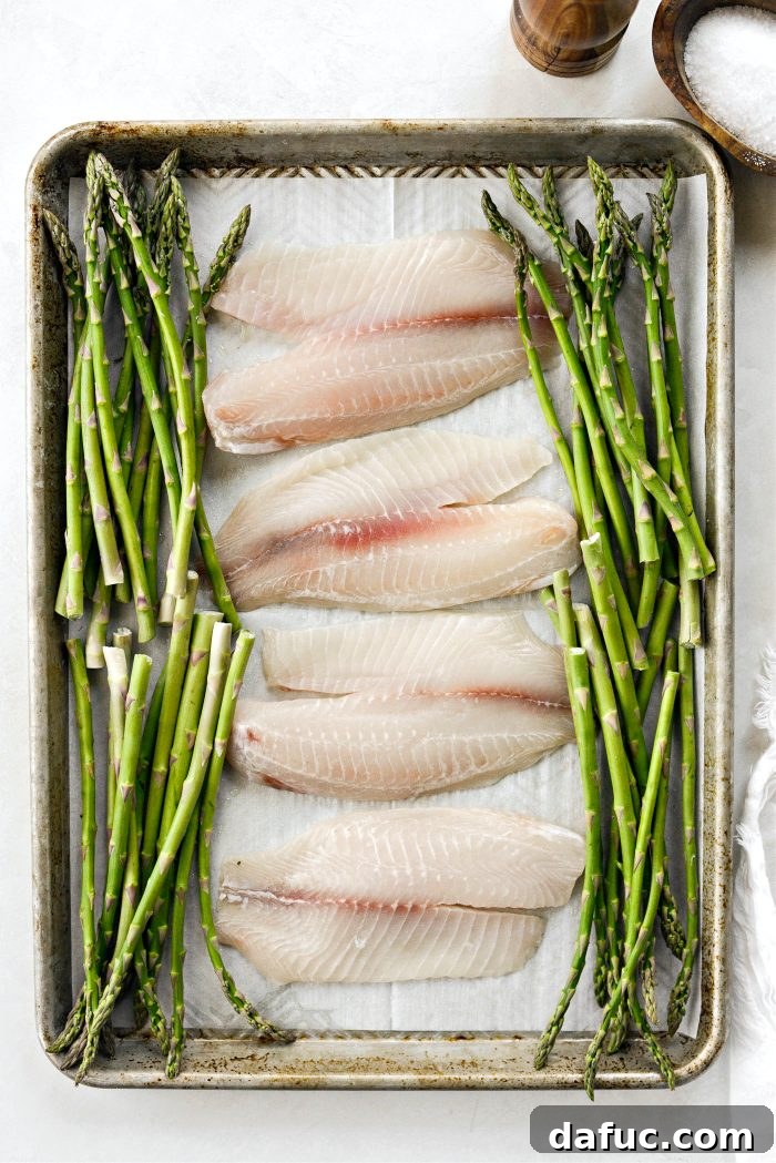 Arranging asparagus spears on a sheet pan with parchment paper