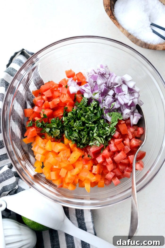Fiesta Slow Cooker Taco Chili 13 Freshly diced red bell pepper, orange bell pepper, roma tomato, red onion, and cilantro for the homemade Bell Pepper Pico de Gallo, a perfect topping for taco chili.