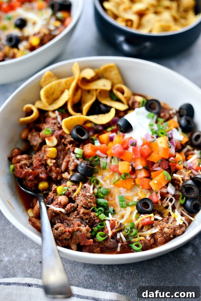 Fiesta Slow Cooker Taco Chili 17 A rustic shot of a bowl of Slow Cooker Taco Chili with toppings, emphasizing its comforting and homemade quality.