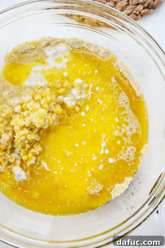 Sweet Mexican Cornbread 8 Melted butter, water, and heavy cream being poured into the bowl with dry ingredients and corn