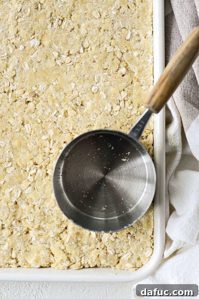 Gently pressing the streusel base into the baking pan