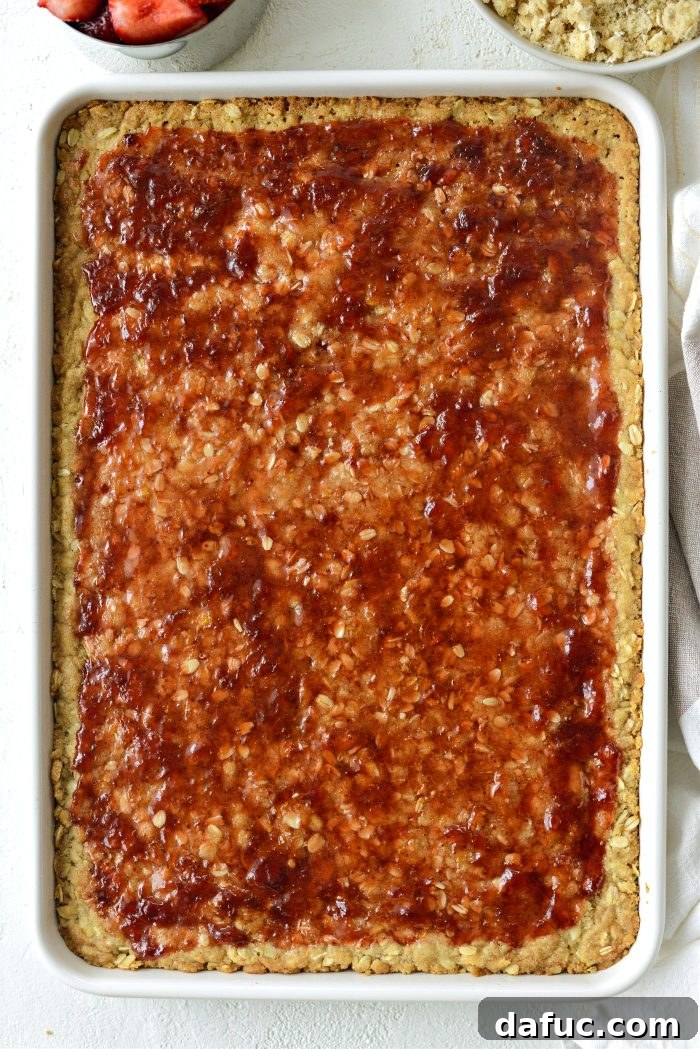 Spreading warm strawberry jam mixture over the partially baked crust