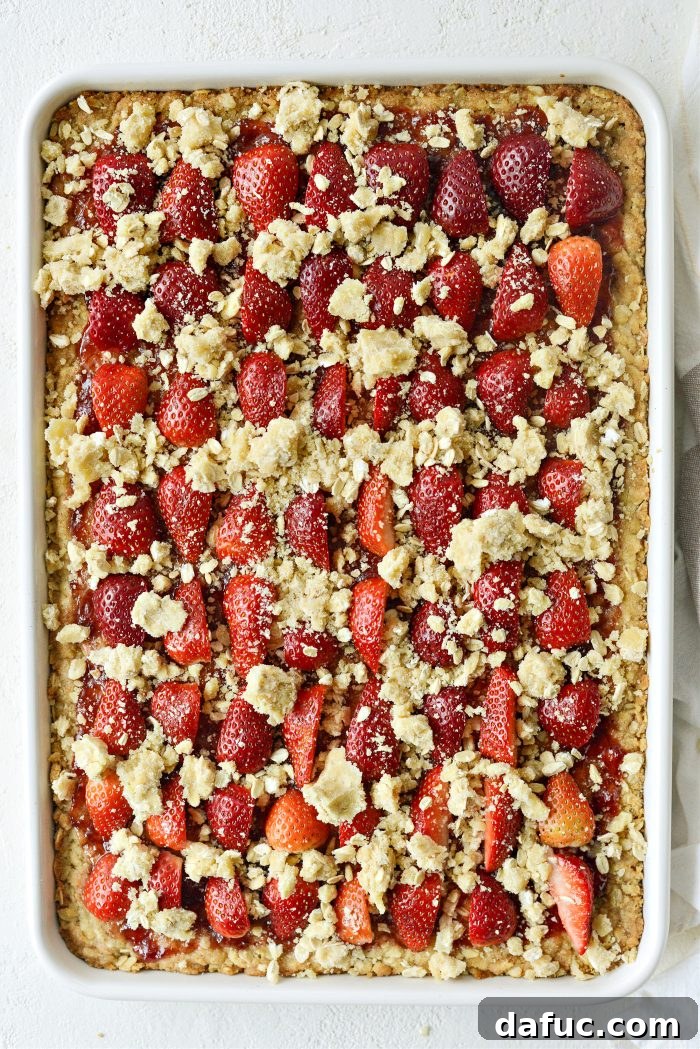 Sprinkling reserved streusel crumb mixture over strawberries and jam