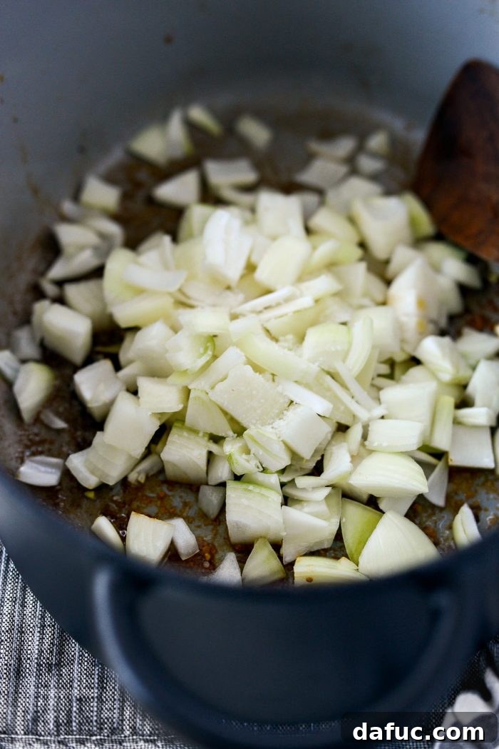 Hearty Homestyle Beef Pot Roast 9 Adding chopped onions to the pot.