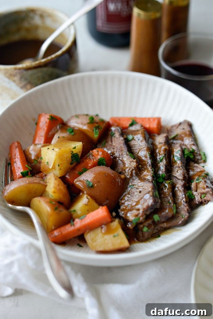 Hearty Homestyle Beef Pot Roast 20 Pot roast with gravy and vegetables on a plate.