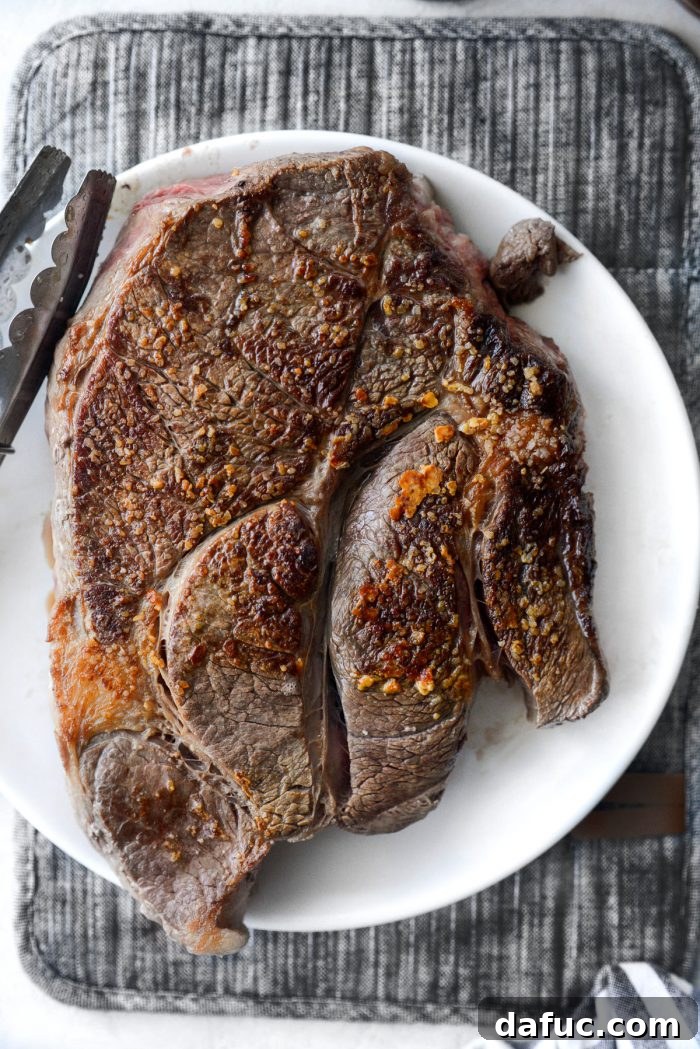 Hearty Homestyle Beef Pot Roast 8 Seared chuck roast resting on a white plate.