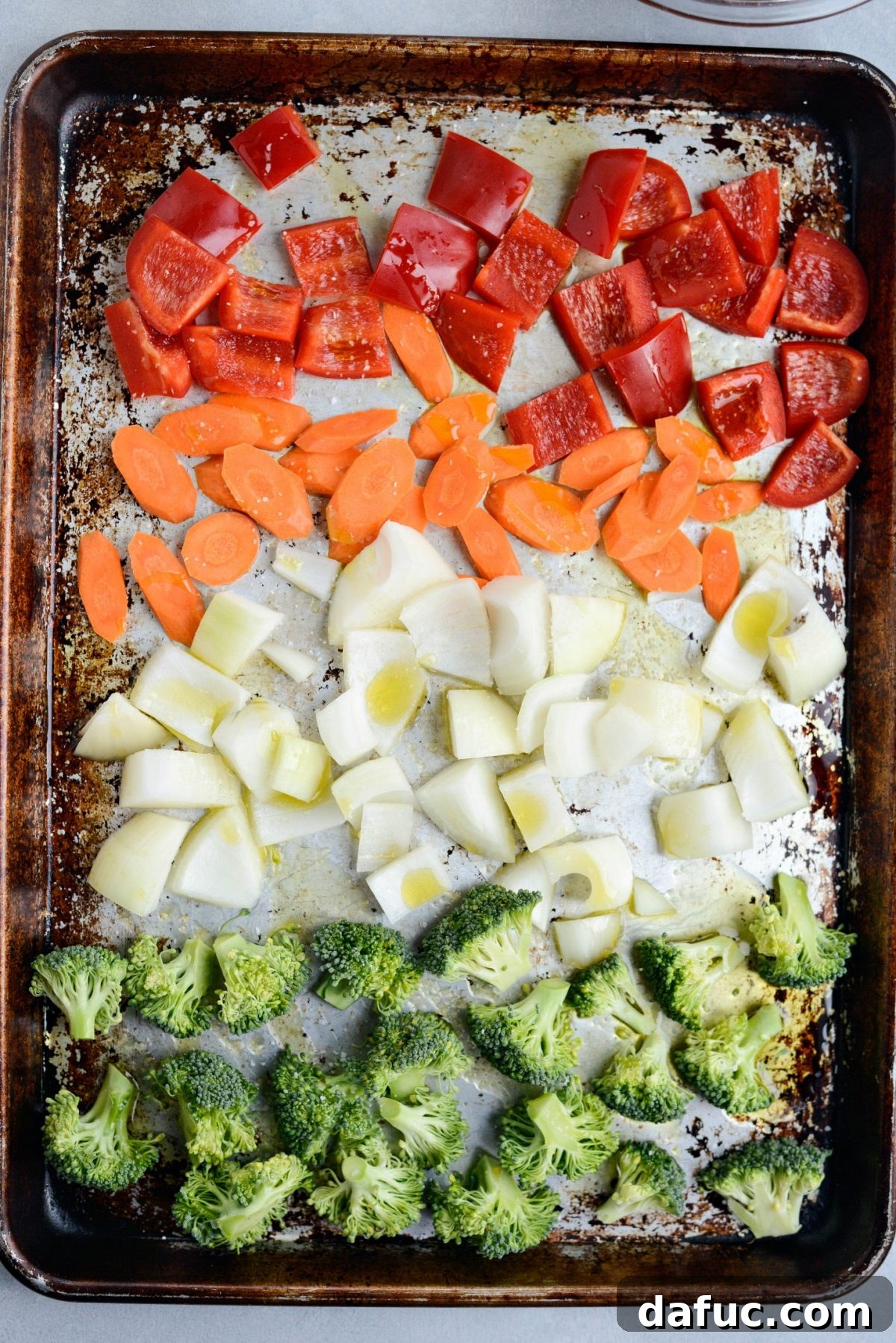 chopped red bell pepper, slice carrots, chopped onions and broccoli florets with olive oil and kosher salt on a rimmed sheet pan