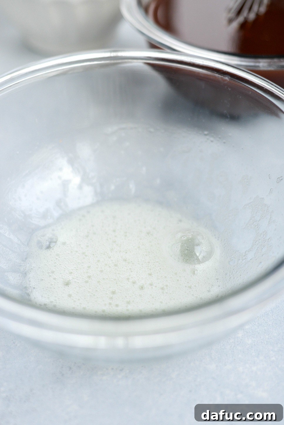 glass bowl of frothy whipped egg whites.