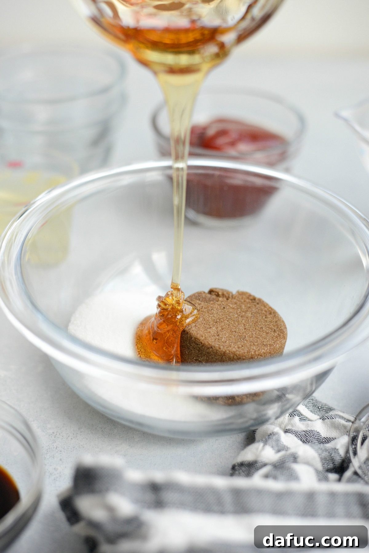 pouring honey into bowl of granulated and dark brown sugar