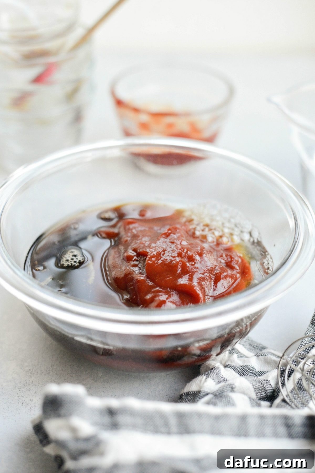 adding ketchup, pineapple juice and low-sodium tamari to glass bowl