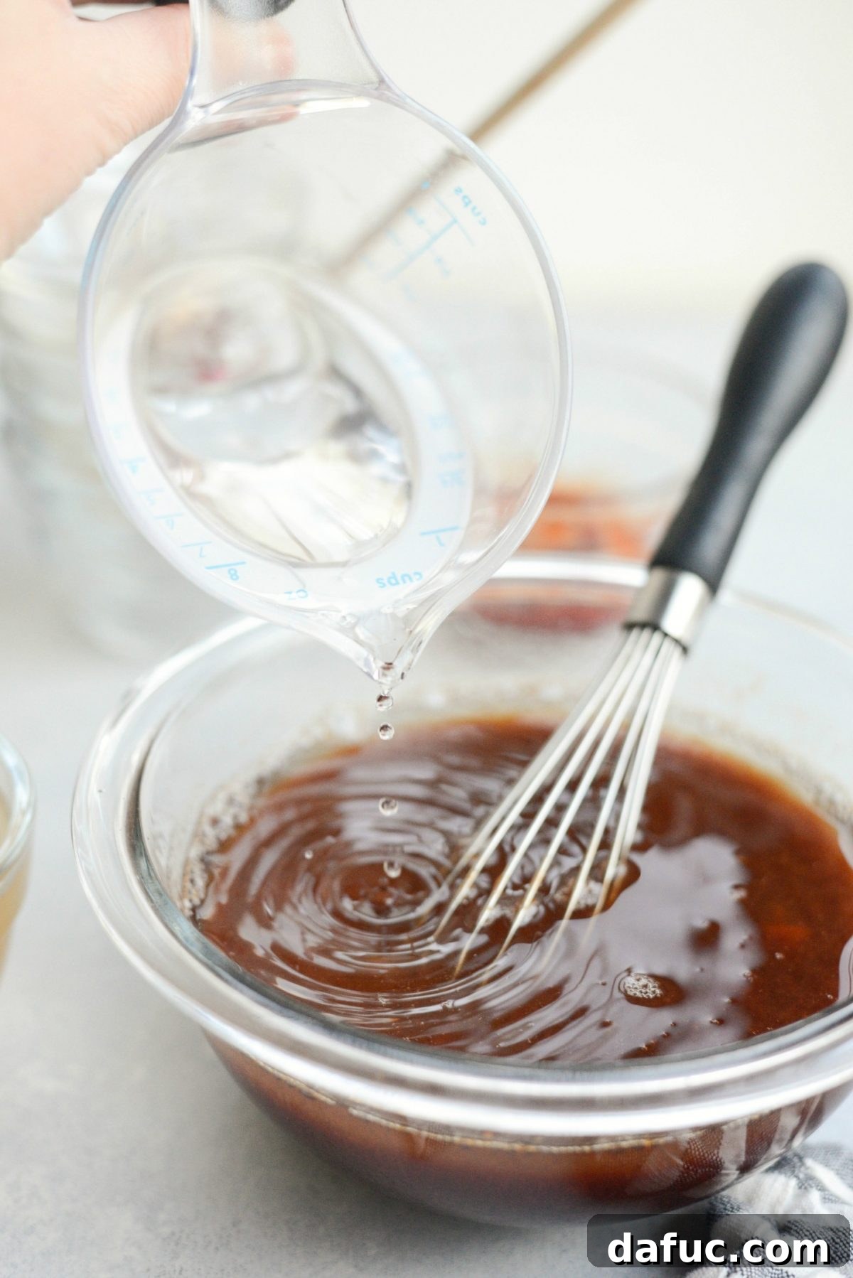 pouring vinegar into sweet and sour sauce