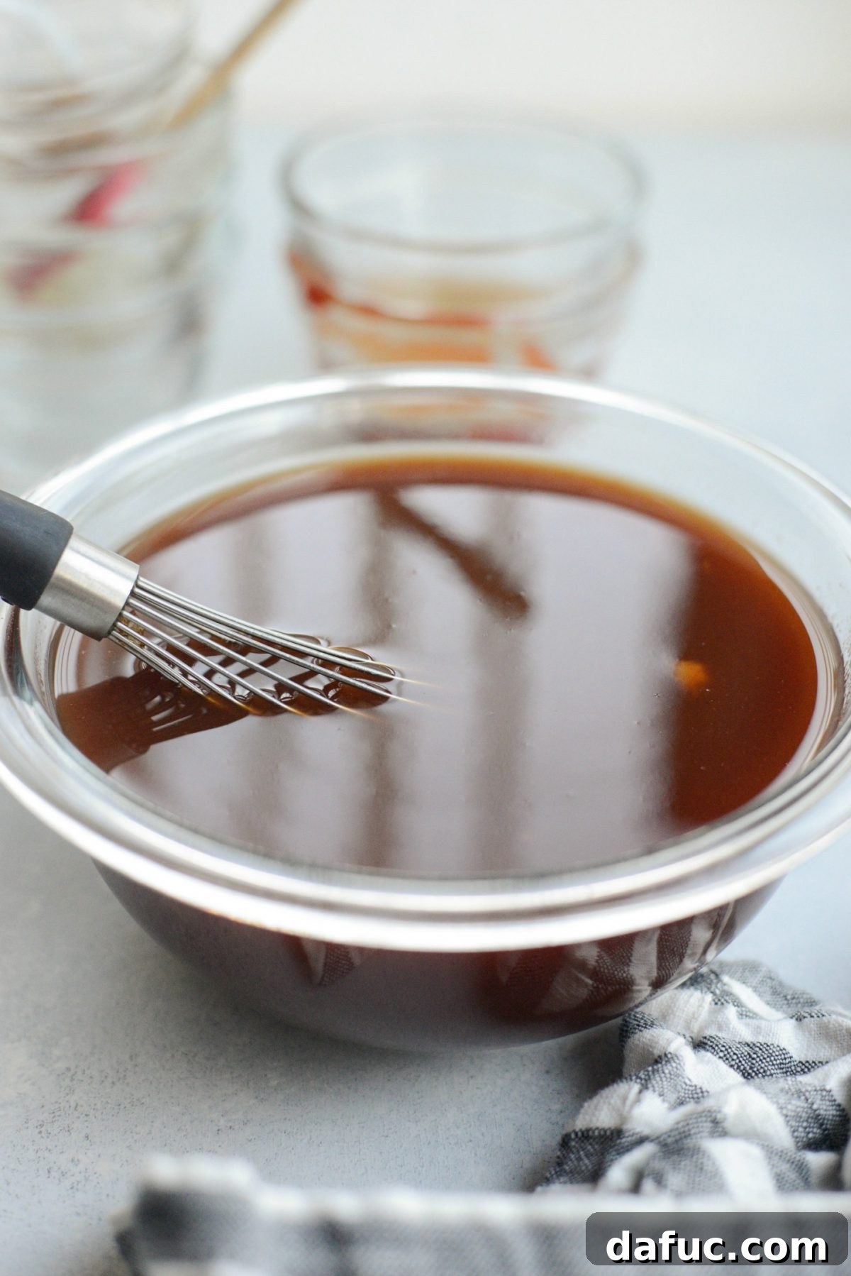 glass bowl of Sweet and Sour sauce with whisk