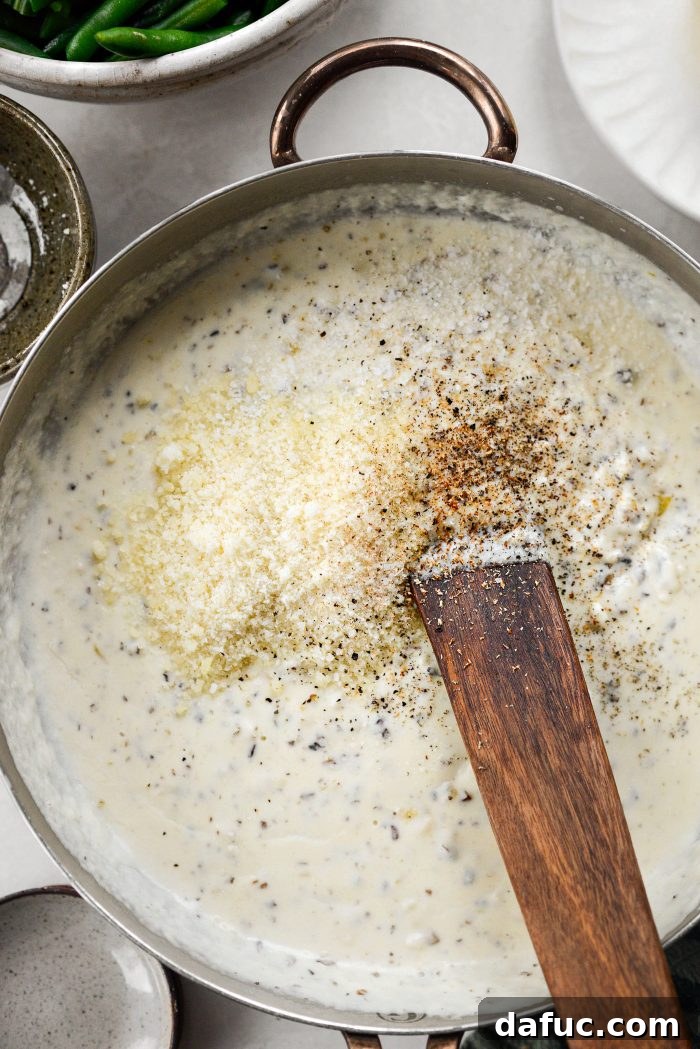 Crispy Shallot Green Bean Casserole 18 Parmesan cheese, salt, pepper, and nutmeg being added to the creamy sauce.