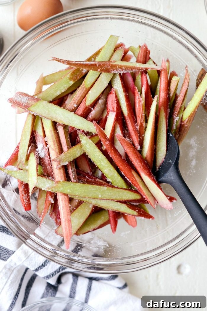 Martha Sweet Rhubarb Flip 9 Close up of sliced rhubarb tossed with sugar in a clear mixing bowl