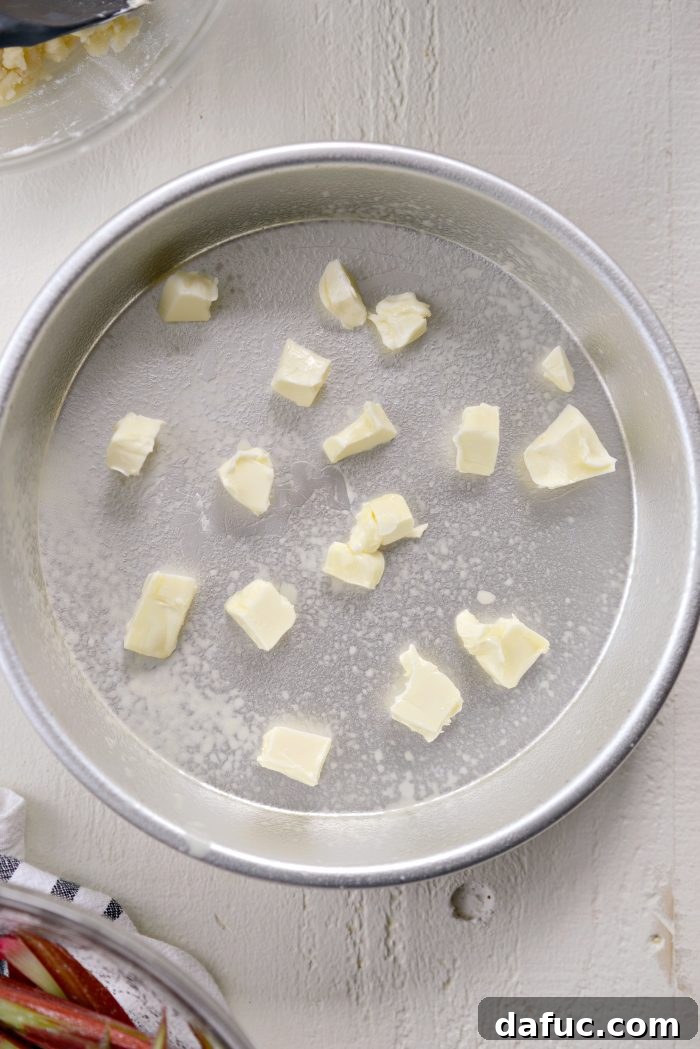 Martha Sweet Rhubarb Flip 10 A greased cake pan dotted with pieces of butter, ready for the rhubarb layer