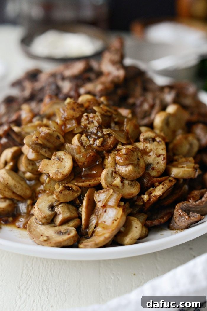 Hearty Homestyle Beef Stroganoff 16 Transferring cooked mushroom mixture to a plate with the seared beef