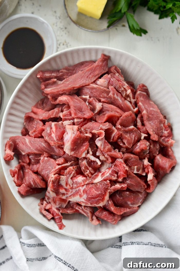 Hearty Homestyle Beef Stroganoff 5 Thinly sliced ribeye steak in a mixing bowl, ready for seasoning