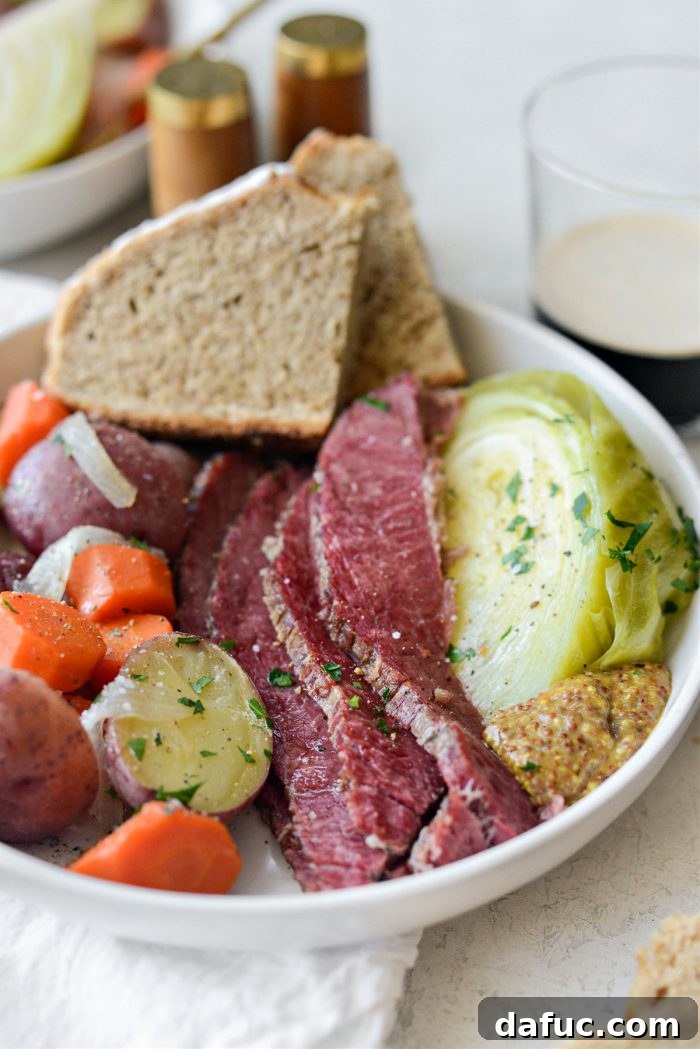 Succulent Corned Beef and Cabbage 3 A vibrant platter of tender corned beef slices alongside perfectly cooked cabbage, carrots, and potatoes, ready for a St. Patrick's Day feast