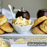 Golden Cornmeal Buttermilk Biscuits with Spicy Jalapeño Cheddar Butter 2 A plate of cornmeal buttermilk biscuits with a scoop of jalapeno cheddar butter on top.
