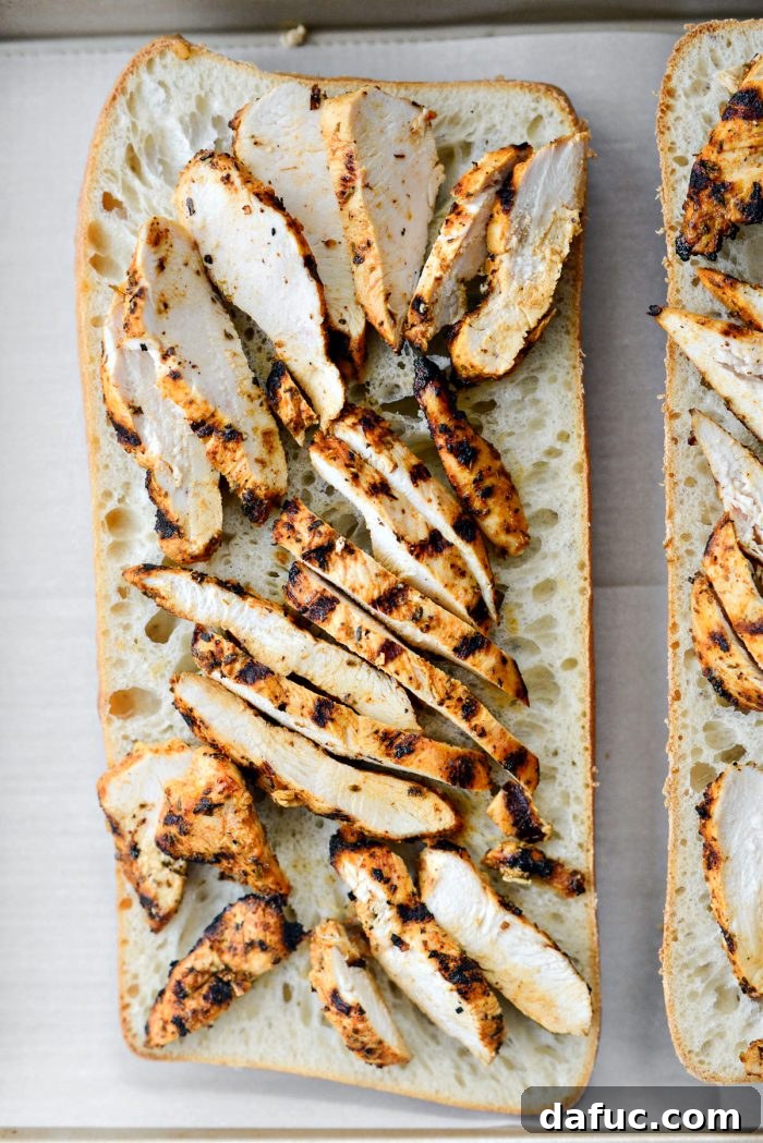 Vibrant Bruschetta Chicken Pizza 11 Ciabatta bread topped with sliced grilled chicken pieces on a baking sheet