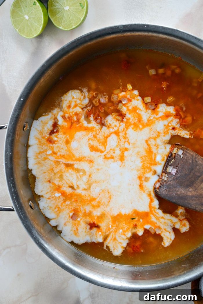 Add broth, light coconut milk and salt