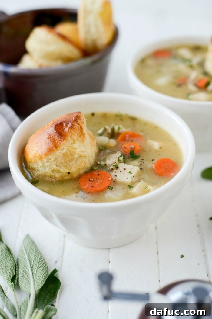 Close-up of a bowl of Turkey Pot Pie Soup with puff pastry and a spoon. Keywords: homemade, turkey, potpie, soup, leftover, fromscratch, thanksgiving, leftovers