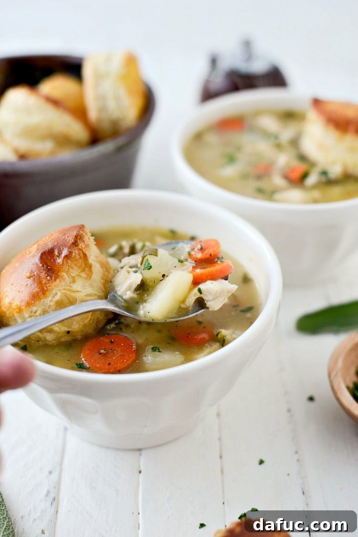 Several bowls of Homemade Turkey Pot Pie Soup served with puff pastry on a rustic table setting. Keywords: homemade, turkey, potpie, soup, leftover, fromscratch, thanksgiving, leftovers