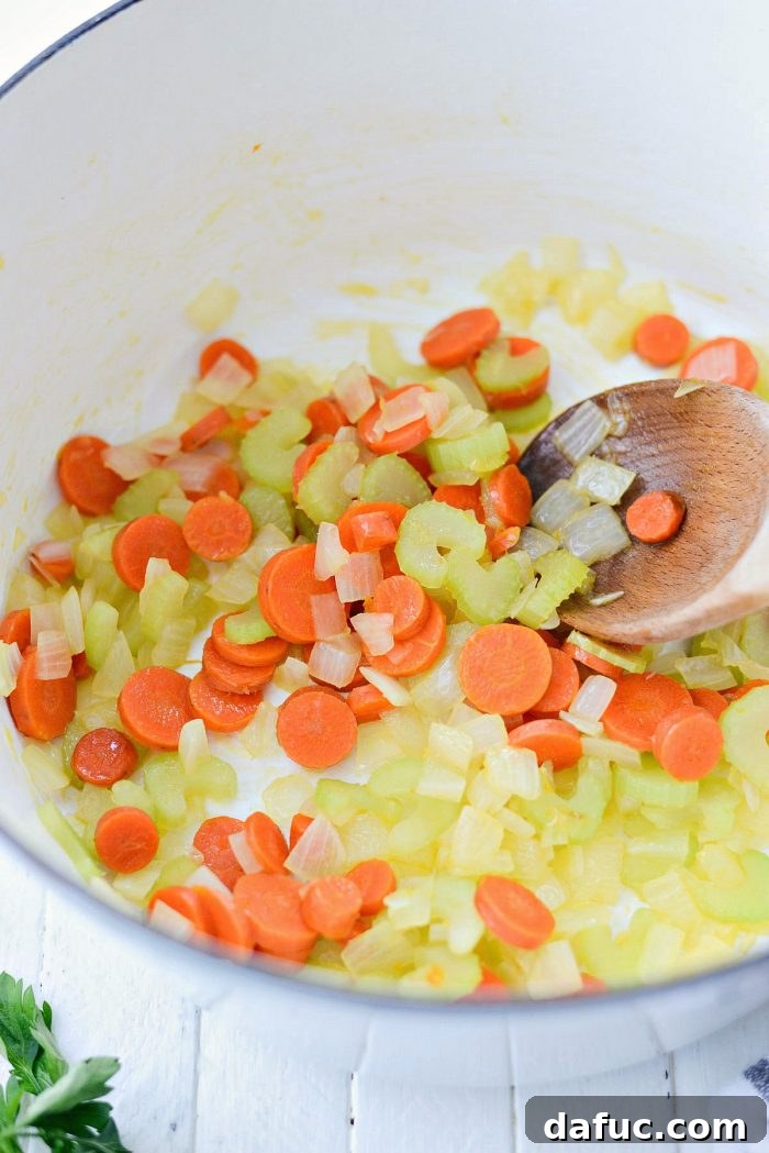 Diced onions, celery, and carrots sautéing in olive oil in a Dutch oven. Keywords: homemade, turkey, potpie, soup, leftover, fromscratch, thanksgiving, leftovers