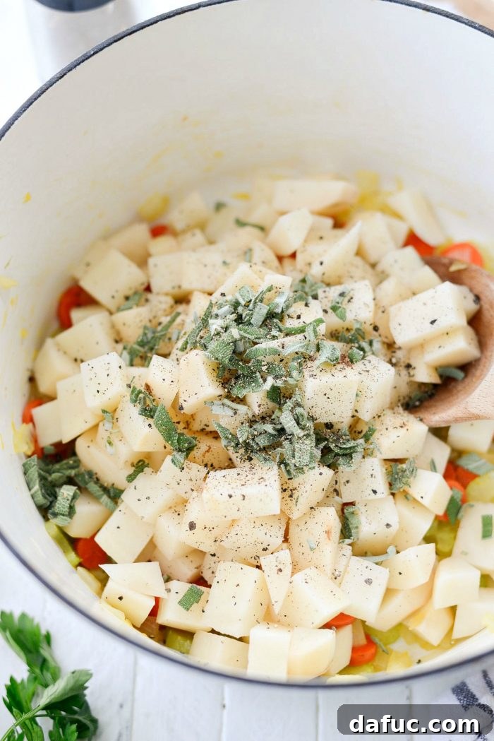 Diced potatoes, fresh sage, and black pepper added to sautéed vegetables in a pot. Keywords: homemade, turkey, potpie, soup, leftover, fromscratch, thanksgiving, leftovers