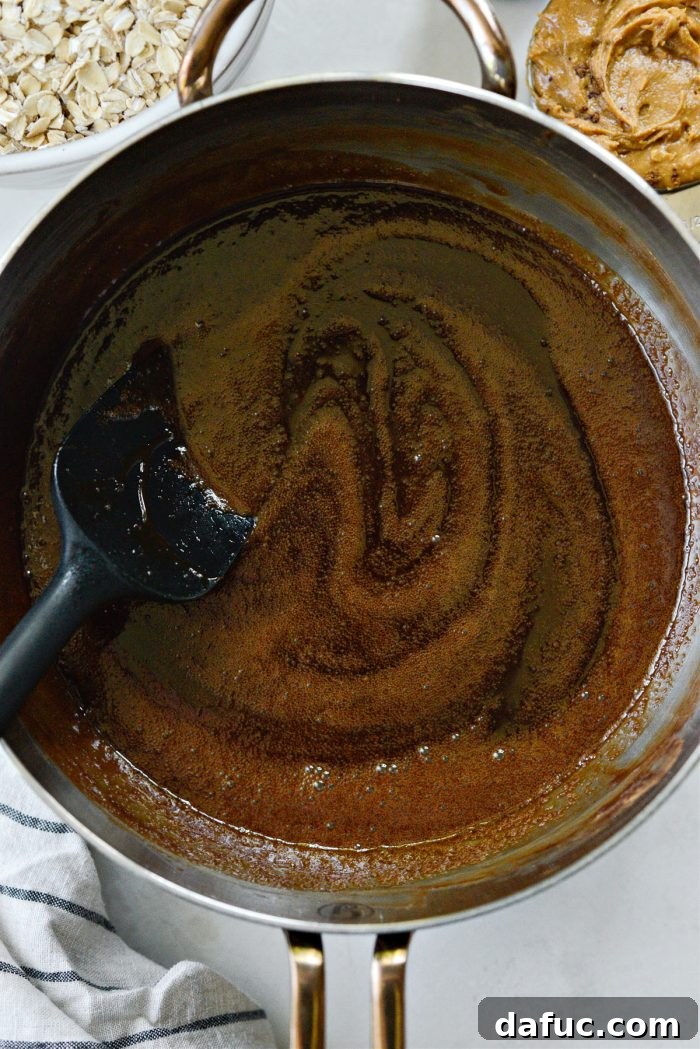 Fudgy No-Bake Oatmeal Delights 7 Chocolate mixture at a rolling boil in a saucepan