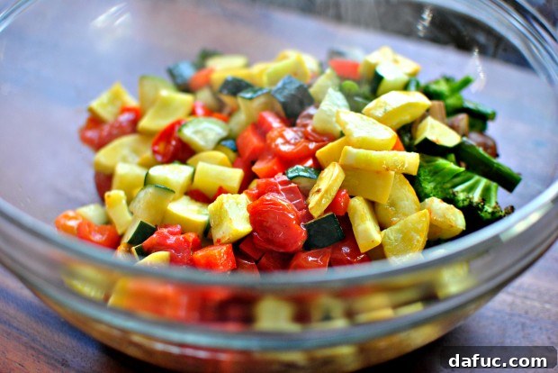 Golden Roasted Vegetable Primavera Pasta 13 Adding roasted tomatoes, zucchini, squash, and pepper to bowl