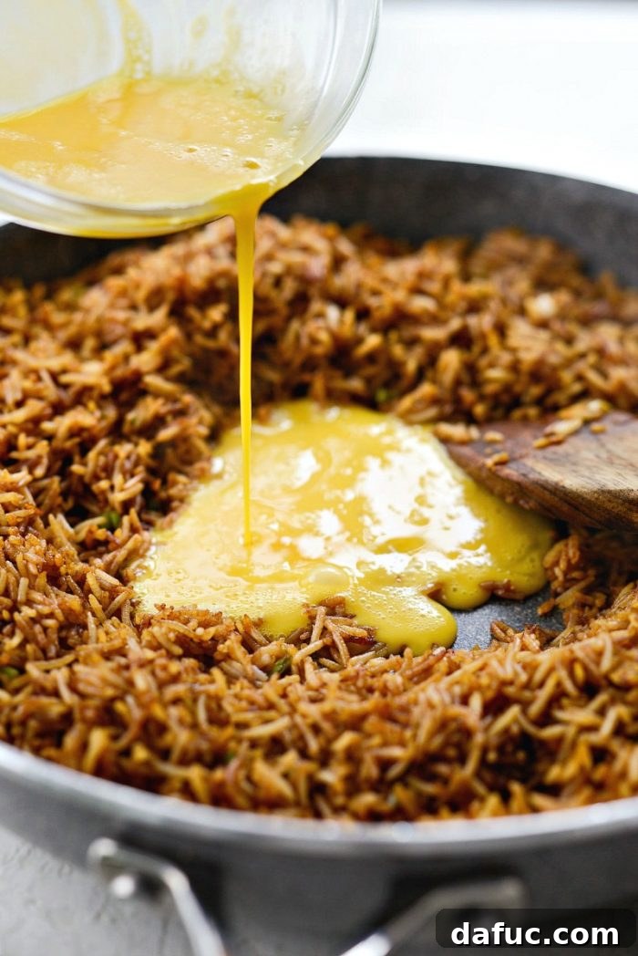 Effortless Fried Rice 12 Making a well in the cooked fried rice to scramble the beaten egg